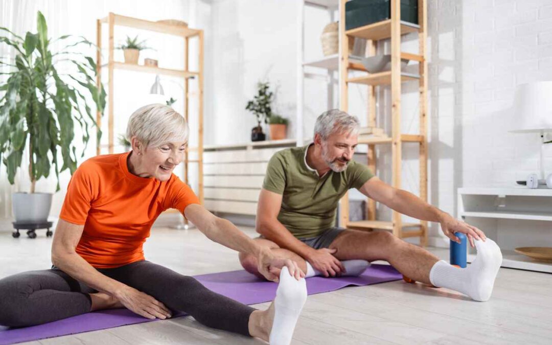 Photo of a heterosexual couple stretching their bodies after doing a home workout. Sports and physical activity; Maintaining Healthy Joints